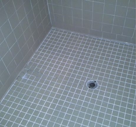 A tiled shower floor with a drain in the middle