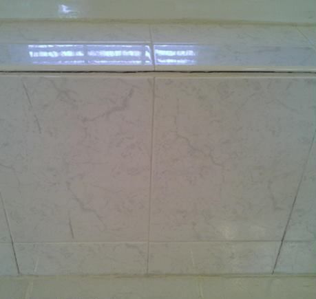 A close up of a tiled ceiling in a bathroom.