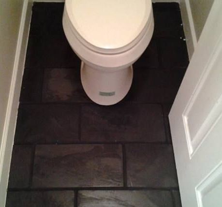 A toilet sits on a tiled floor in a bathroom