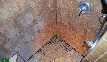 A shower stall with a tiled floor and a shower head.