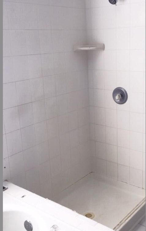 A bathroom with a walk in shower and a sink.