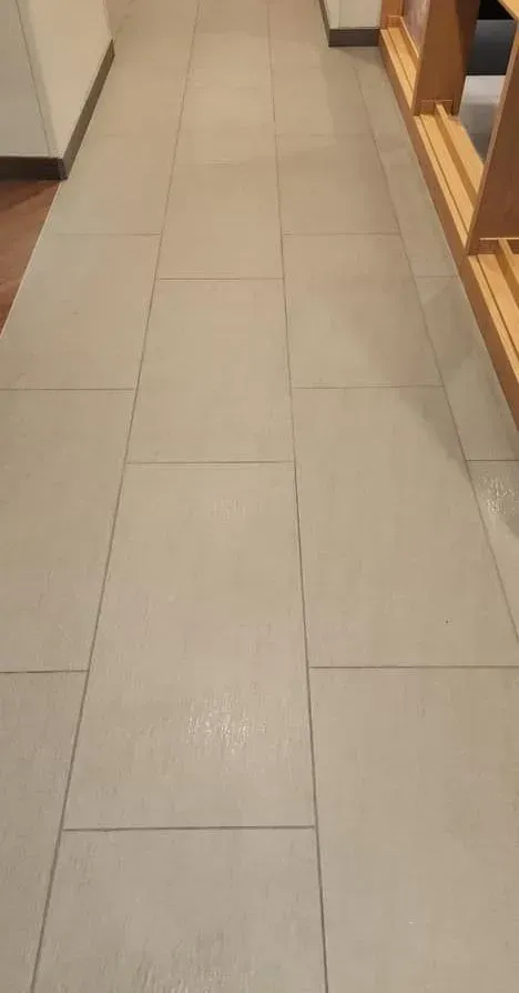 A shower stall in a bathroom with tiled walls