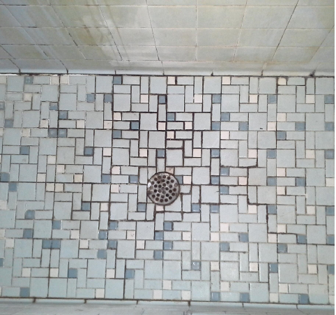A tiled floor with a drain in the middle