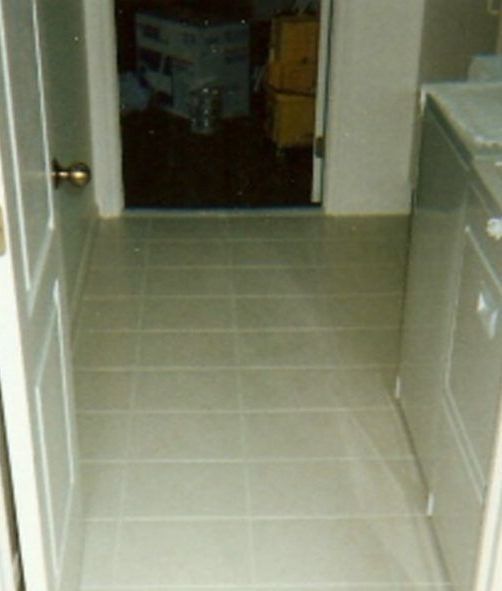 A laundry room with white tile floors and a washer and dryer