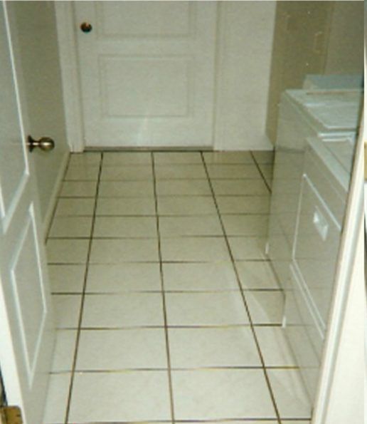 A laundry room with white tile floors and a washer and dryer