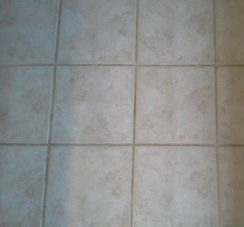 A close up of a tiled floor with a blue border