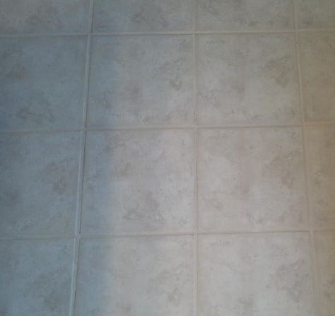 A close up of a tiled floor with a white grout.