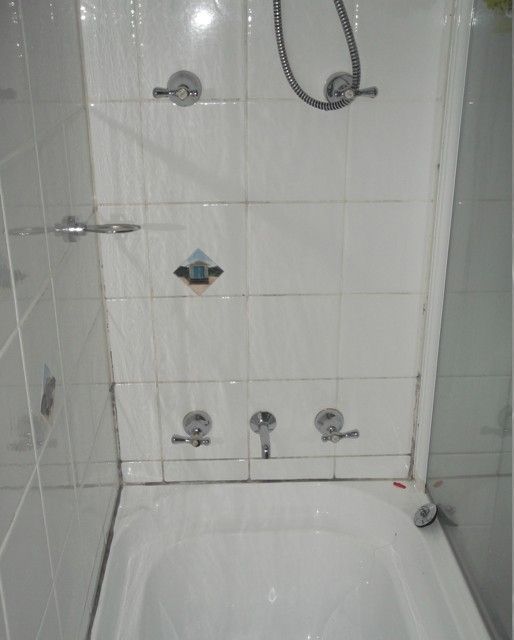A bathtub in a bathroom with a shower head