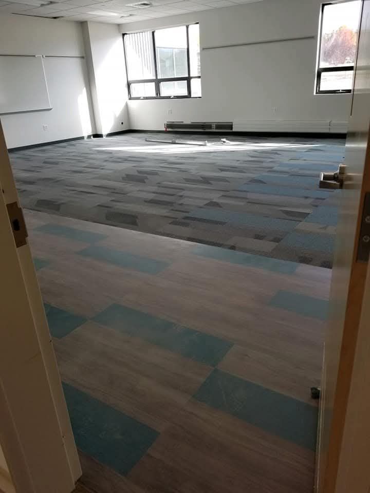 Hallway with speckled floor, plant in pot, and seating area with a sofa.
