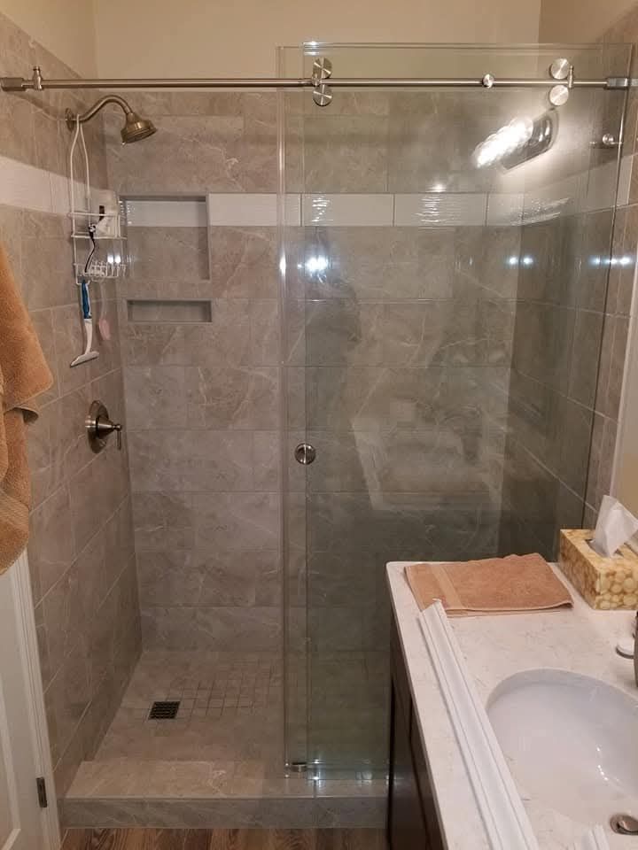 Showerhead with water cascading in a teal-toned bathroom.