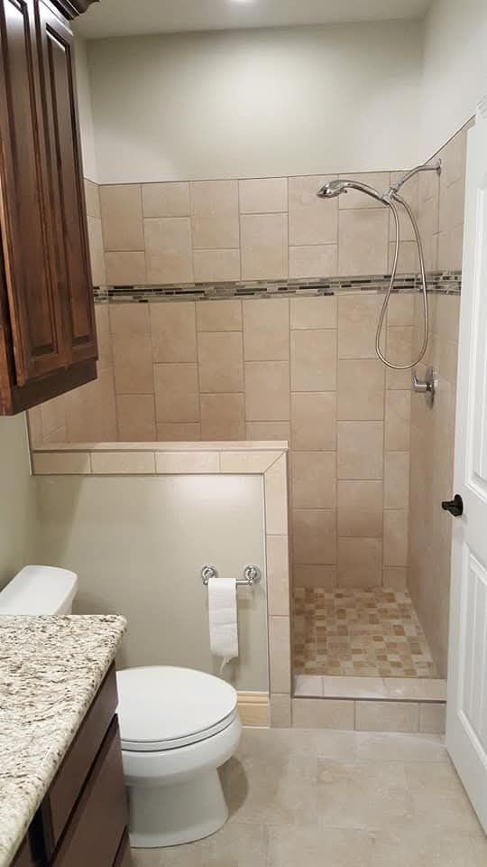 Bathroom with shower, toilet, and vanity. Beige tile walls, granite countertop, and dark wood cabinets.