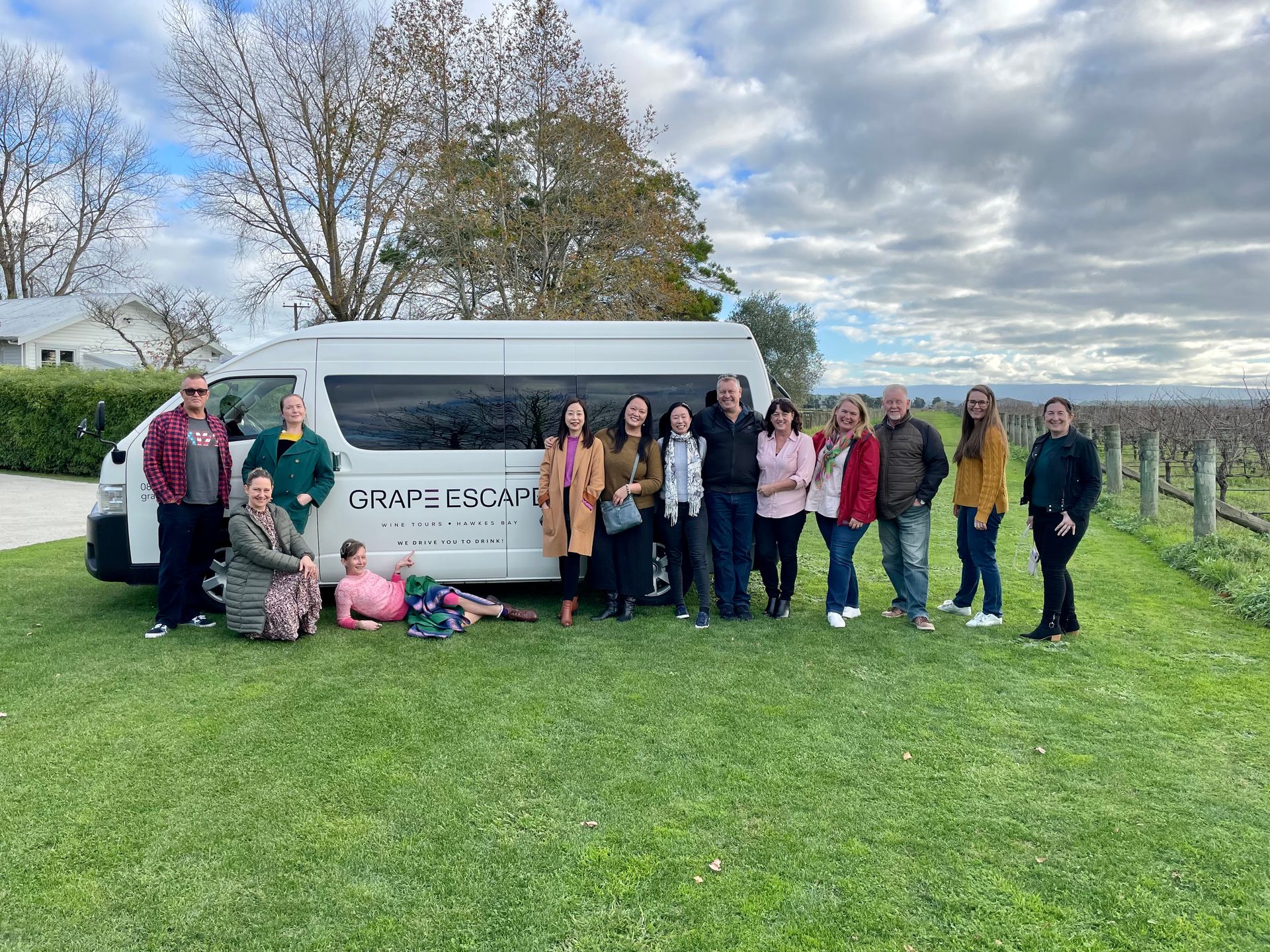 Tour group posing beside Grape Escape tour bus
