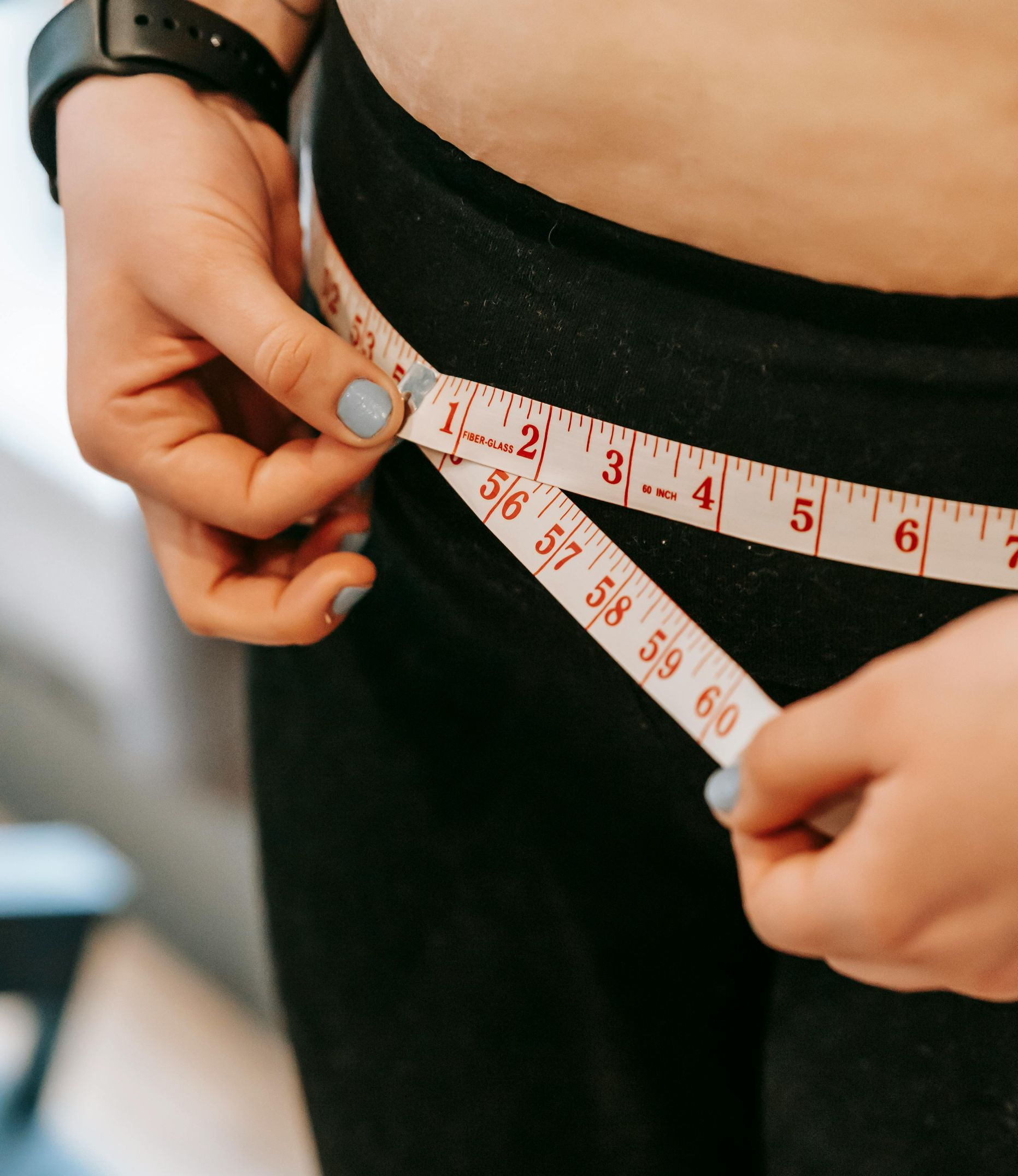 measuring tape around person's waist