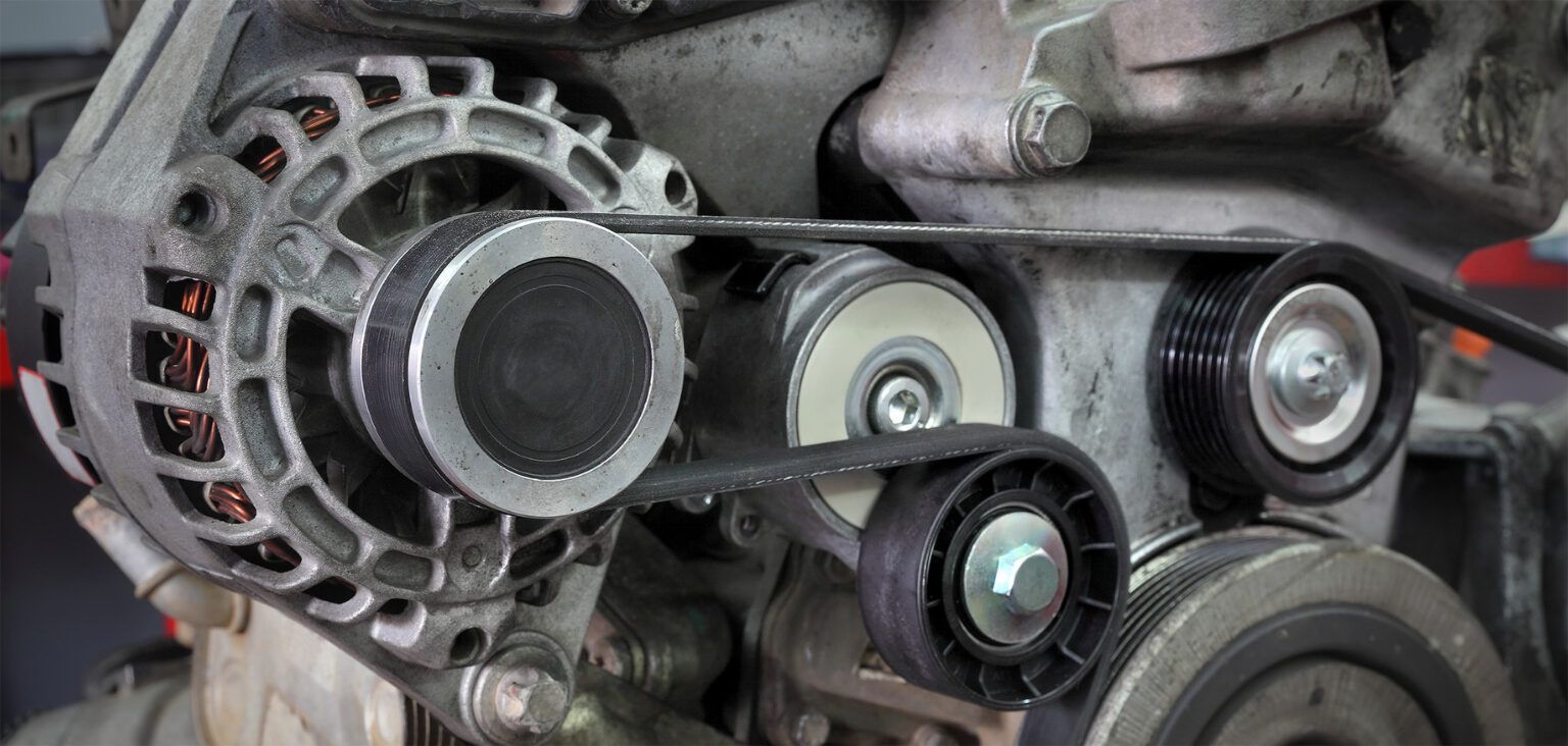 Car engine accessory belt and pulleys, including the alternator, viewed close up