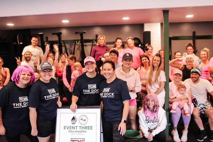 A large group of people are posing for a picture in a gym.