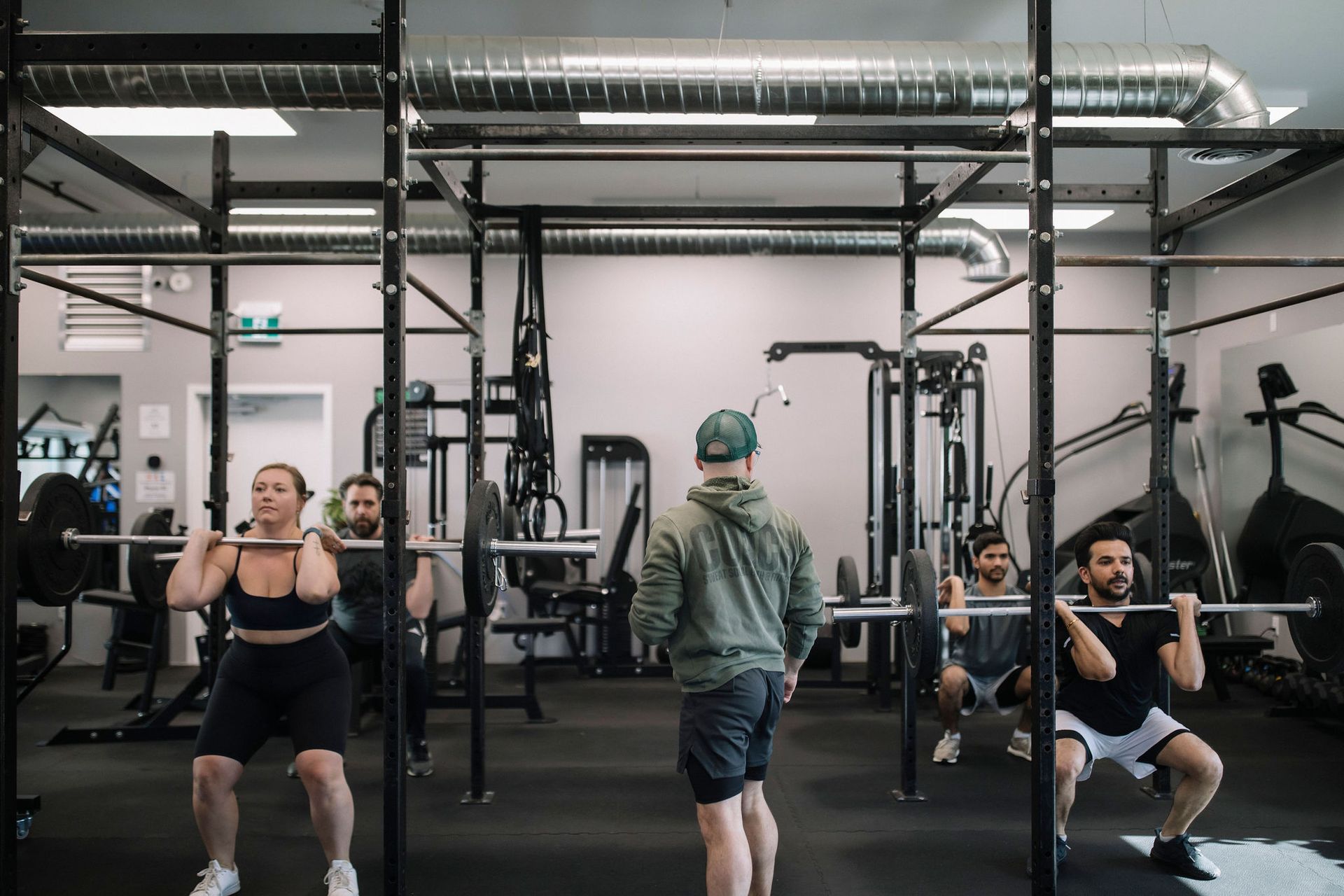 A group of women are lifting dumbbells in a bells of steel gym