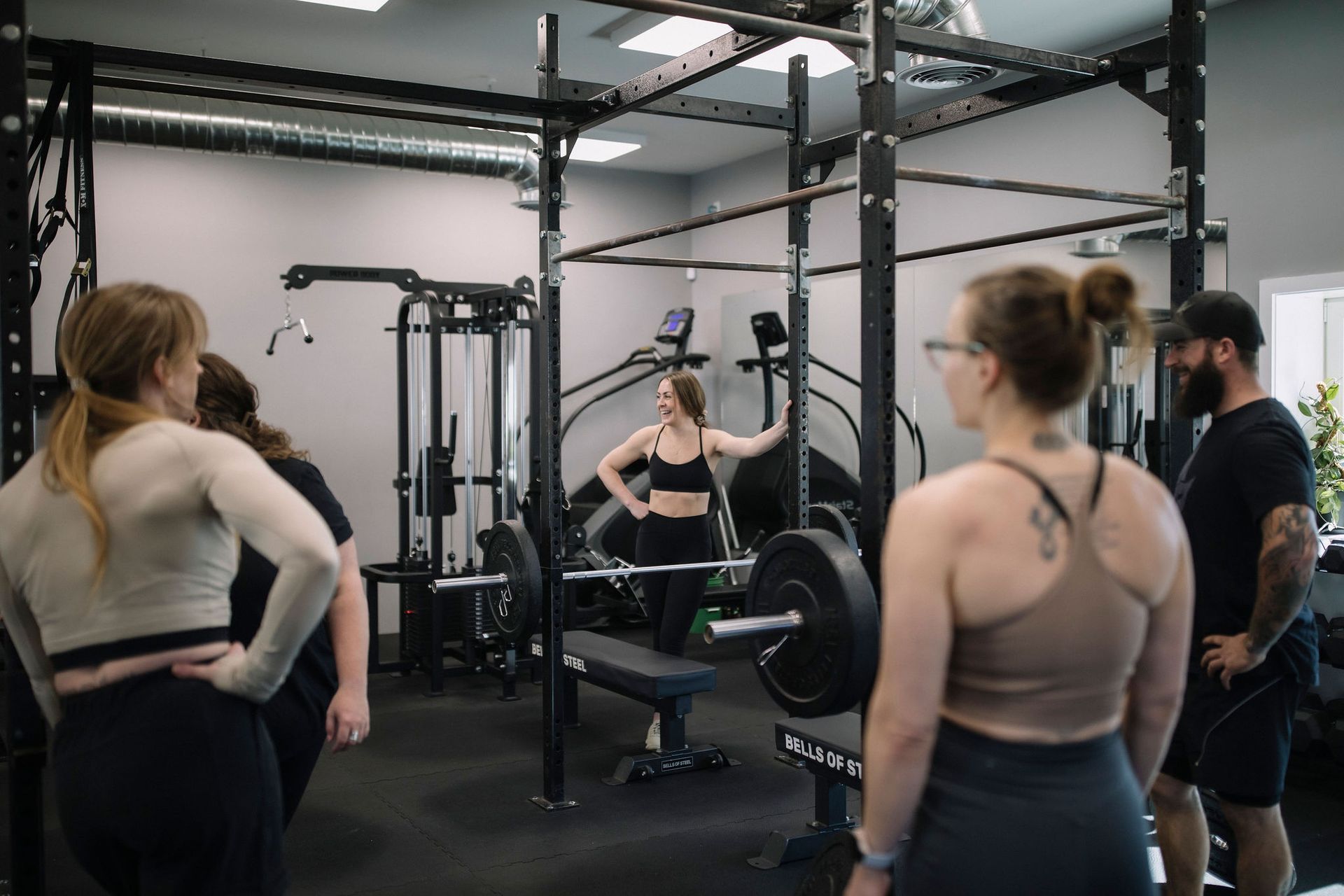 A woman is laying on a bench lifting dumbbells