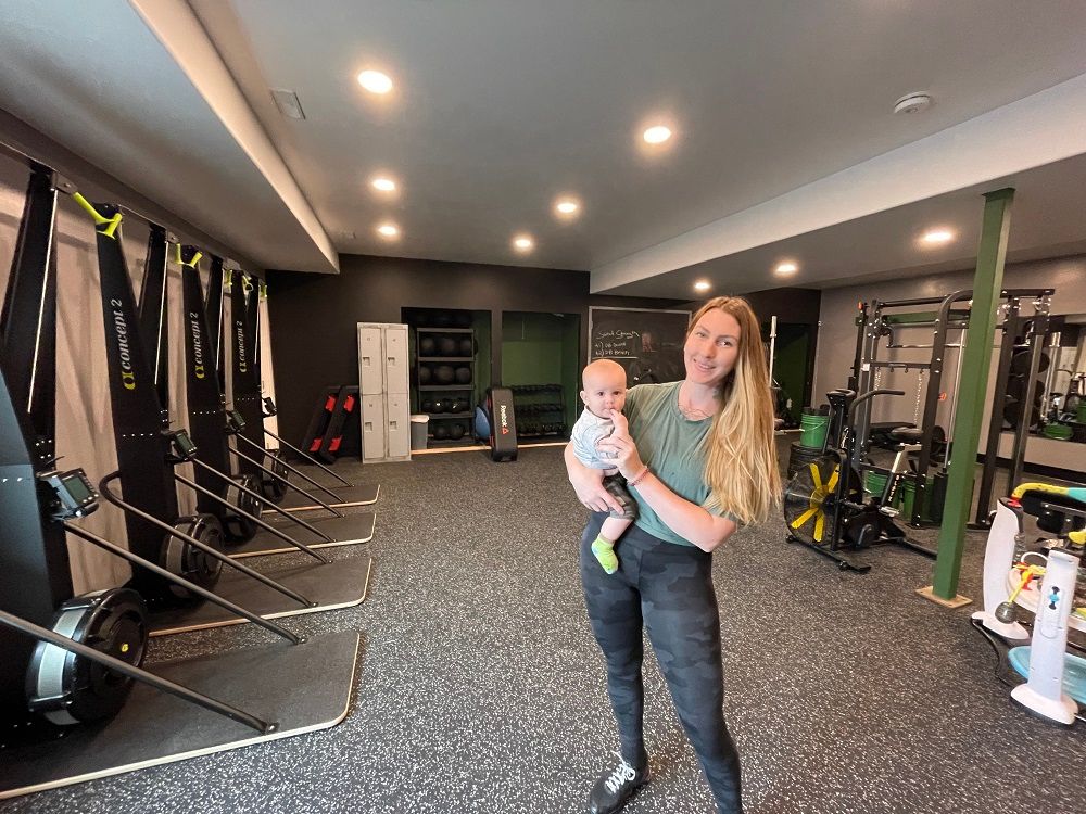 A woman is holding a baby in a gym.