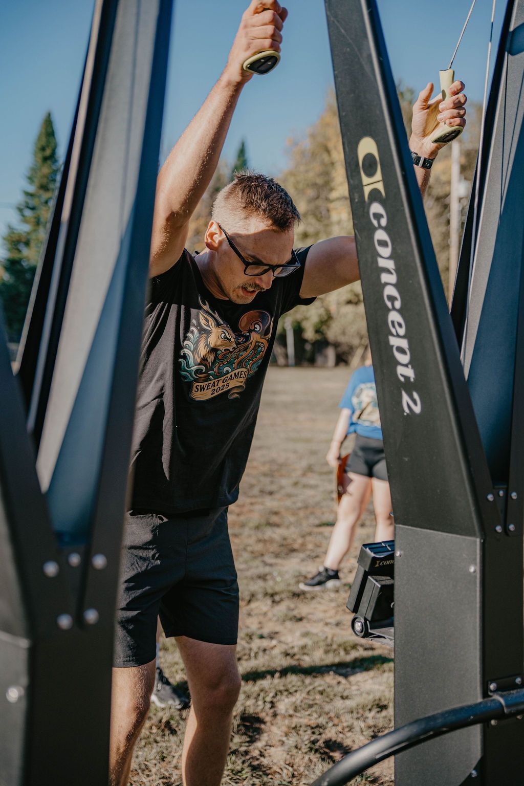 A woman is helping another woman lift a barbell in a gym