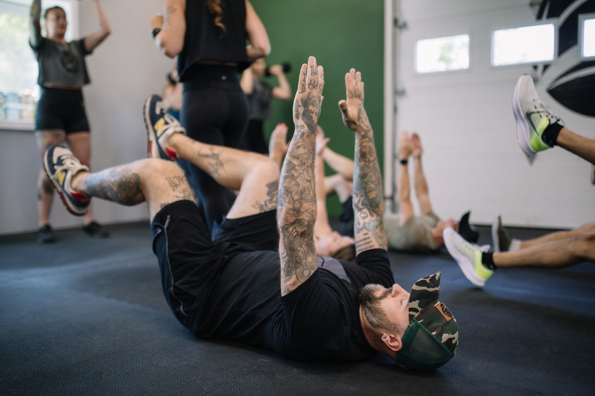 A group of people are doing exercises on the floor in a gym.