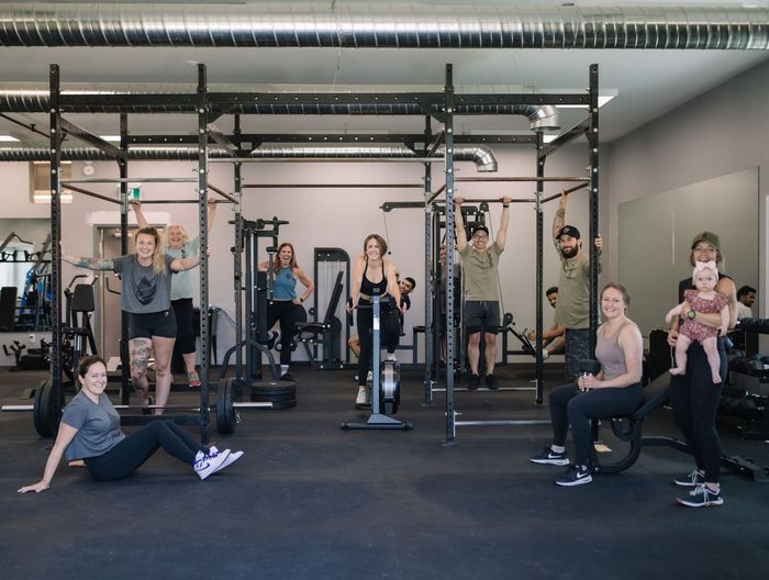 A woman is laying on a bench lifting dumbbells