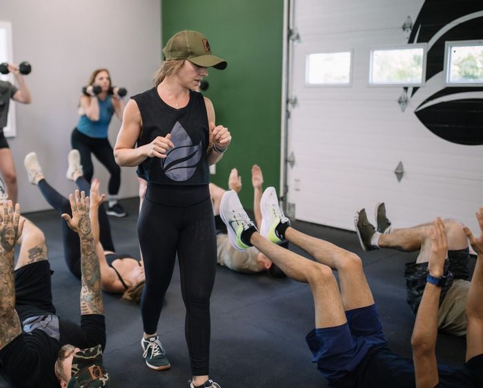 A group of women are lifting dumbbells in a bells of steel gym