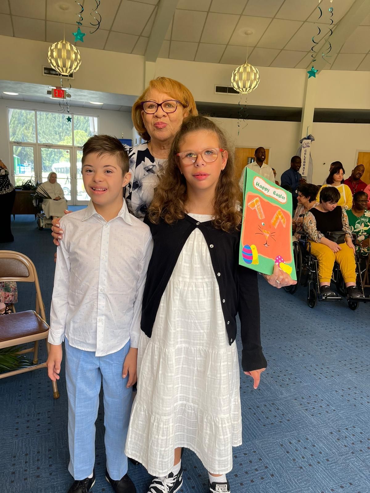 A woman and two children are posing for a picture in a room.
