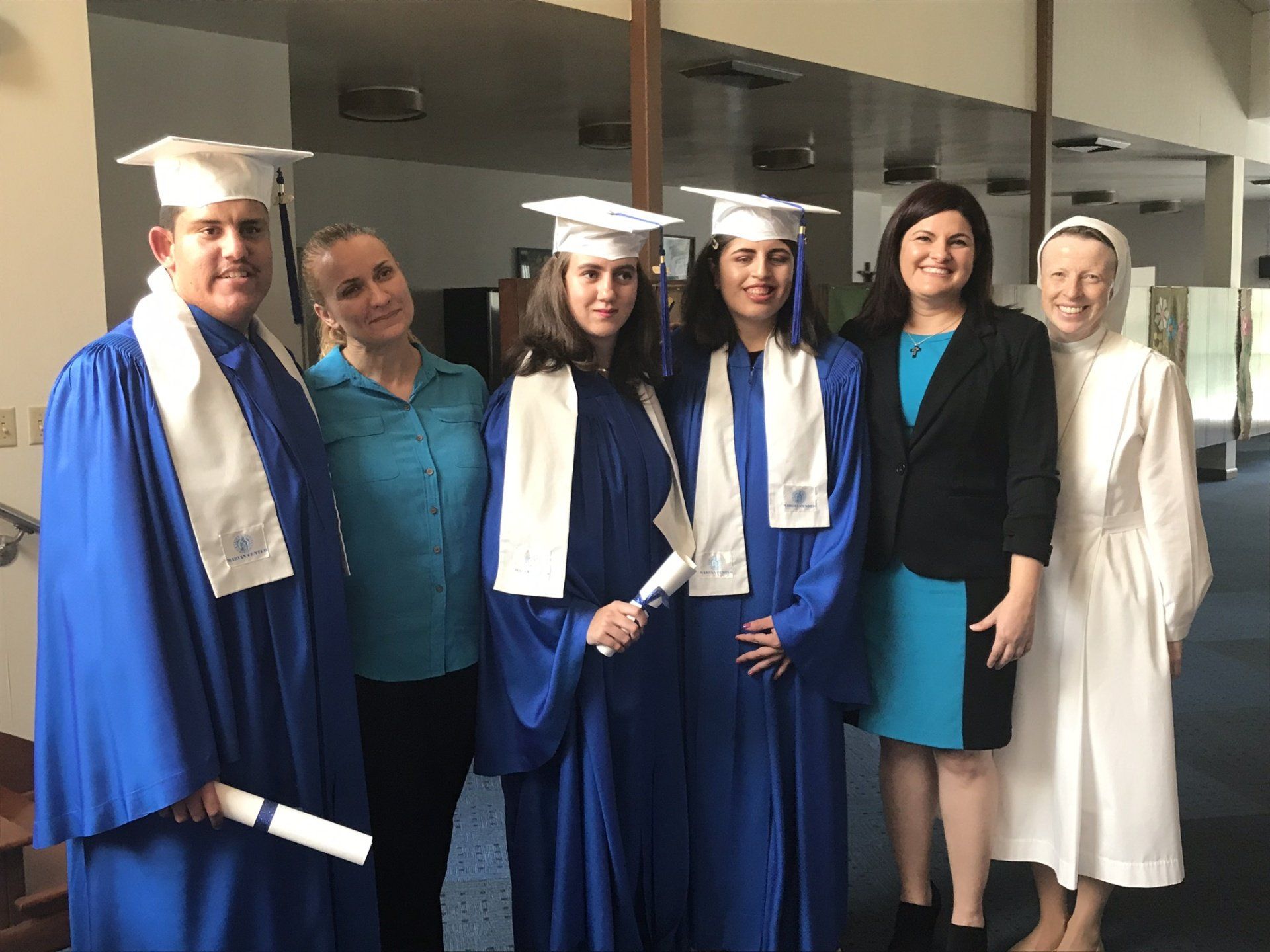 A group of people wearing graduation caps and gowns are posing for a picture.