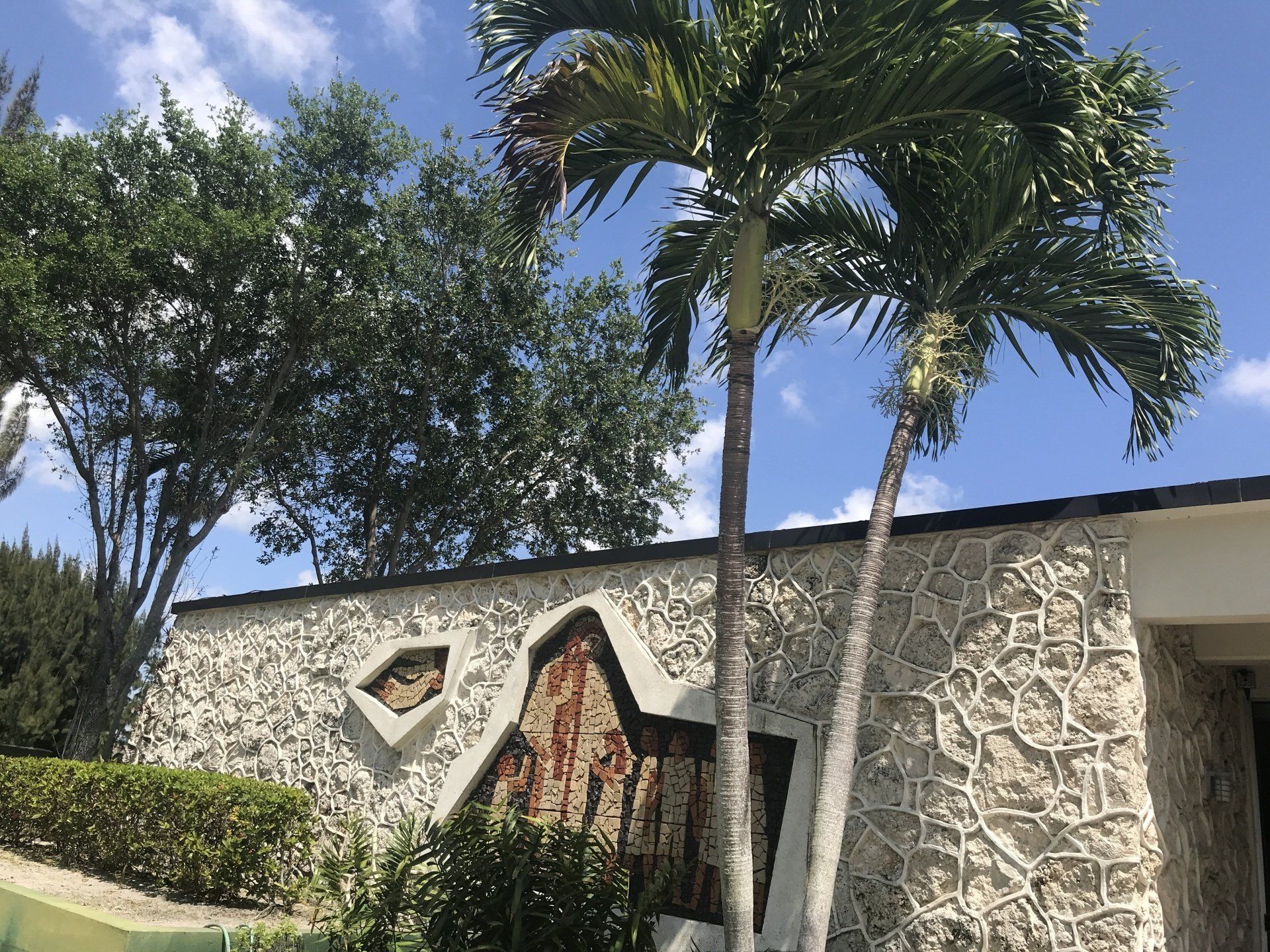 A stone building with a palm tree in front of it