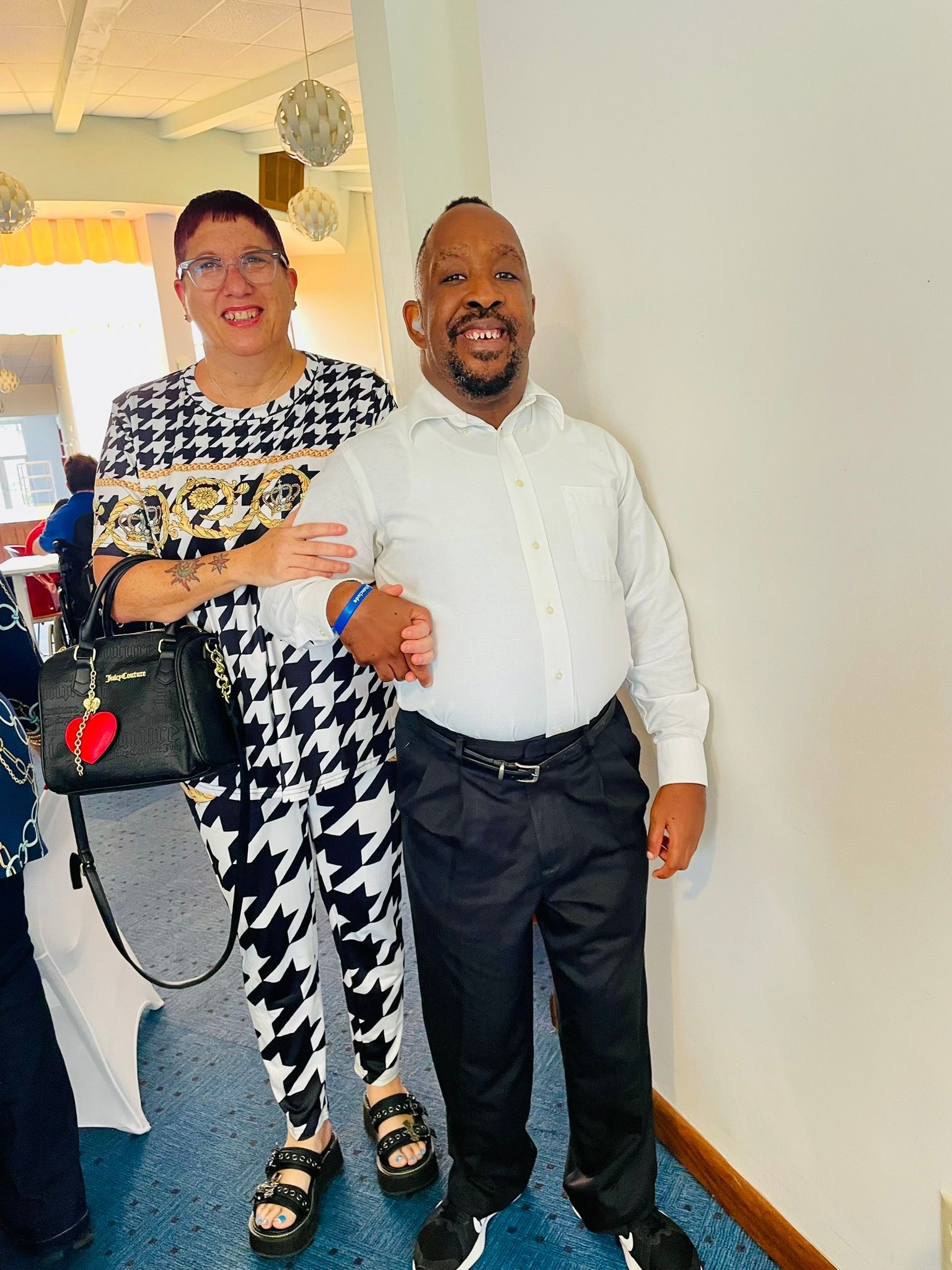 A man and a woman are standing next to each other in a room.