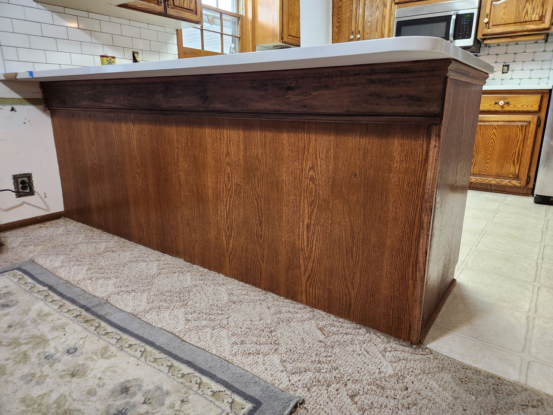 Wooden kitchen island with a white countertop.