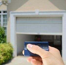 hand holding a garage door opener for a home in Kingwood, TX