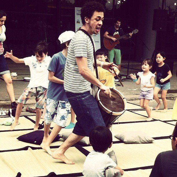 Um homem tocando tambor na frente de um grupo de crianças