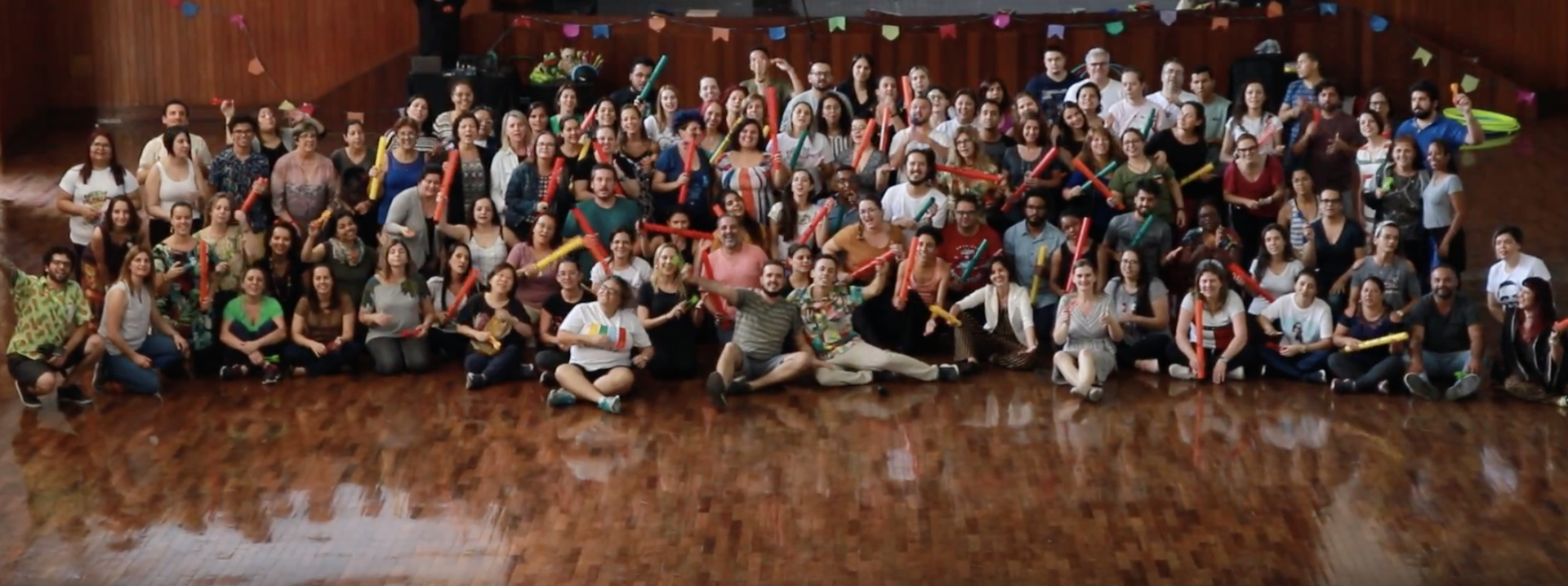 Um grande grupo de pessoas posa para uma foto em uma sala.