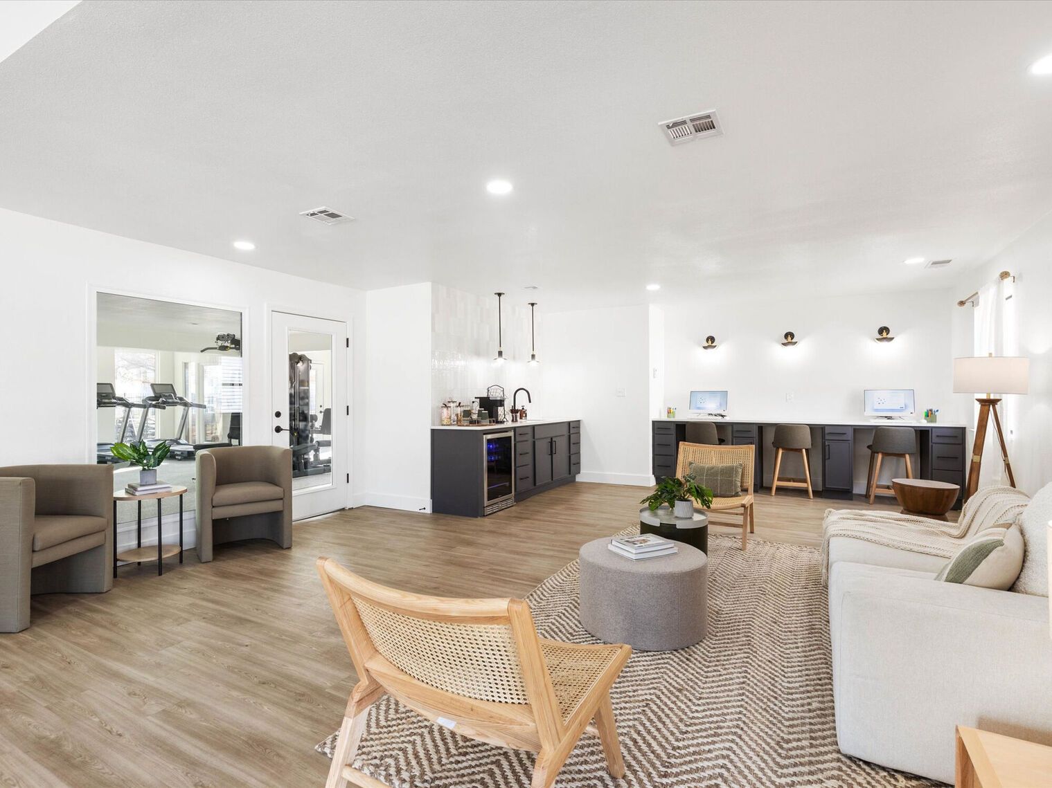 Modern waiting room with neutral tones, seating, and a small refreshment area.