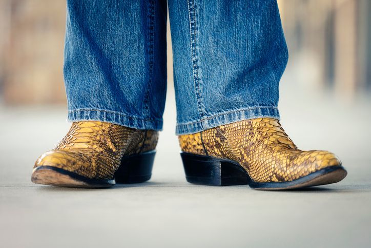 Una persona que lleva un par de botas de vaquero y jeans.