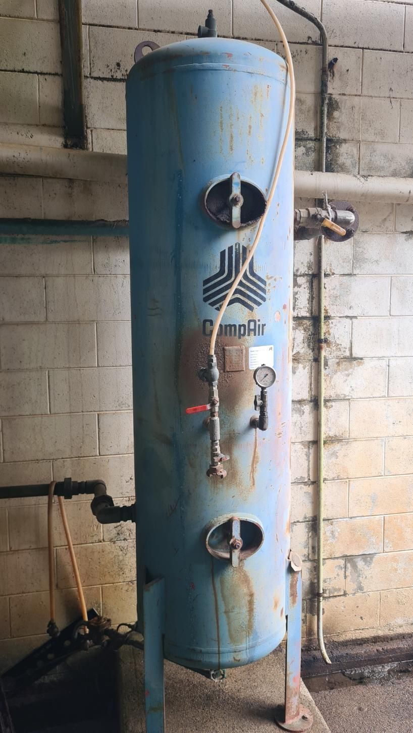 A Blue Tank Is Sitting In A Room Next To A Brick Wall — LJ's Technical Services In Burdell, QLD