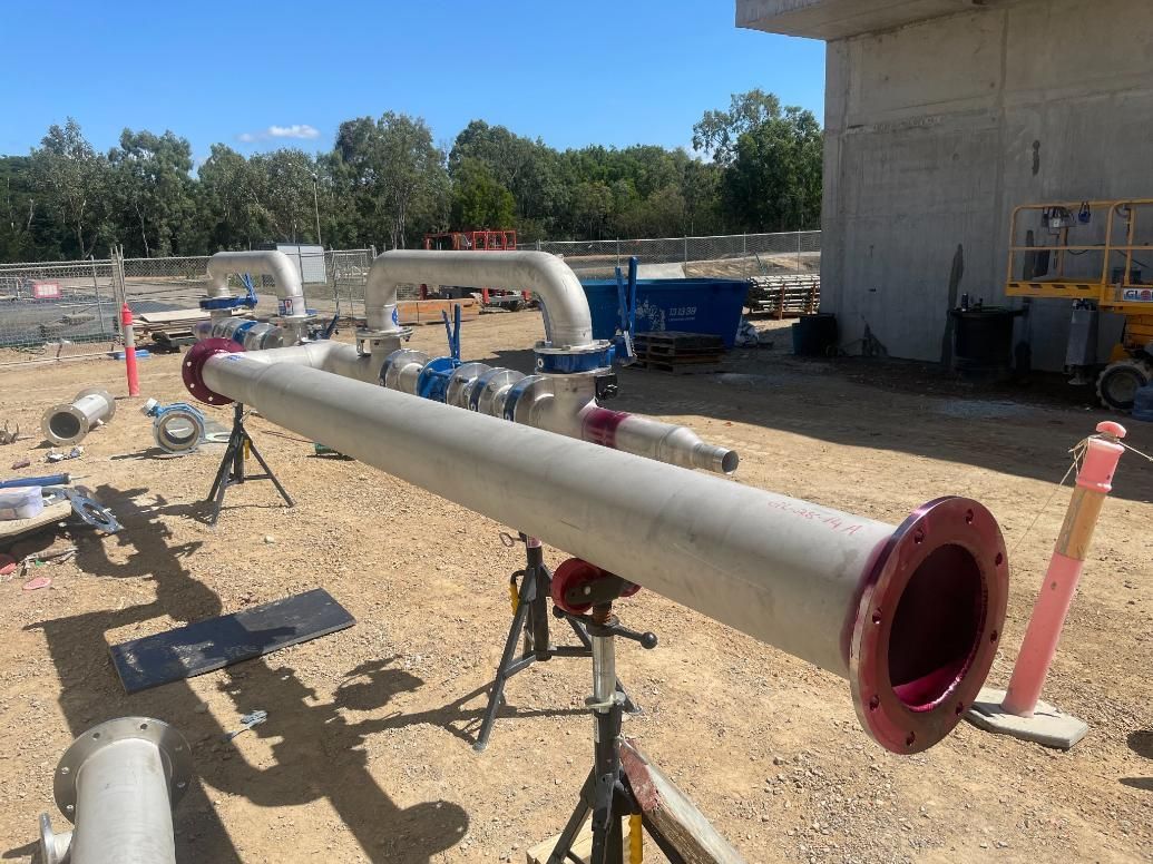 A Large Pipe Is Sitting On A Stand In A Dirt Field — LJ's Technical Services In Cairns, QLD