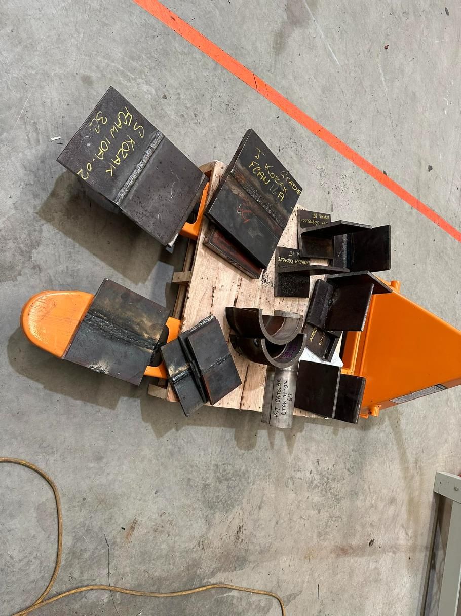 A Bunch Of Metal Pieces Are Sitting On Top Of A Wooden Pallet — LJ's Technical Services In Burdell, QLD