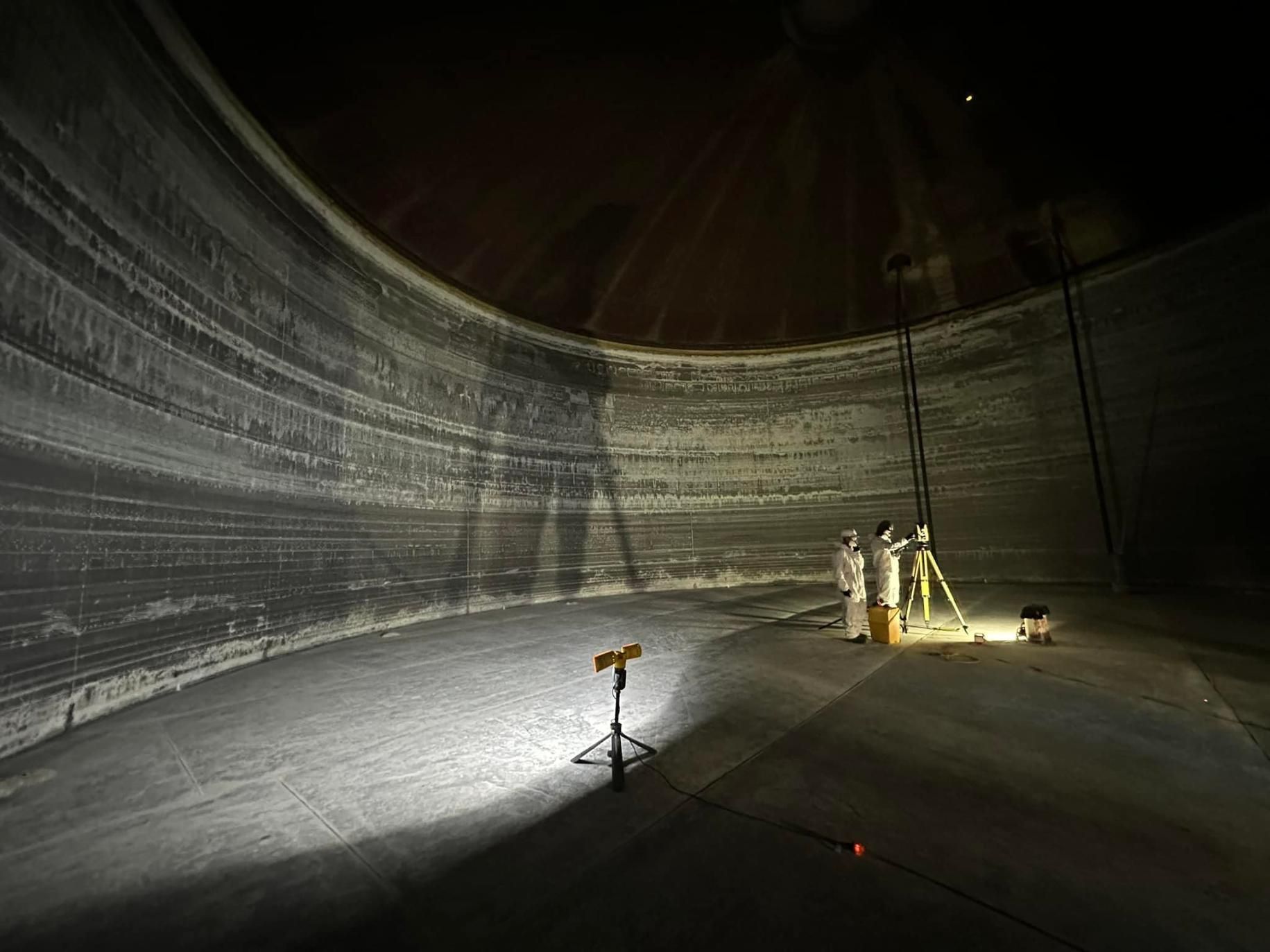 A Group Of People Are Standing In A Large Empty Tank — LJ's Technical Services In Gladstone, QLD
