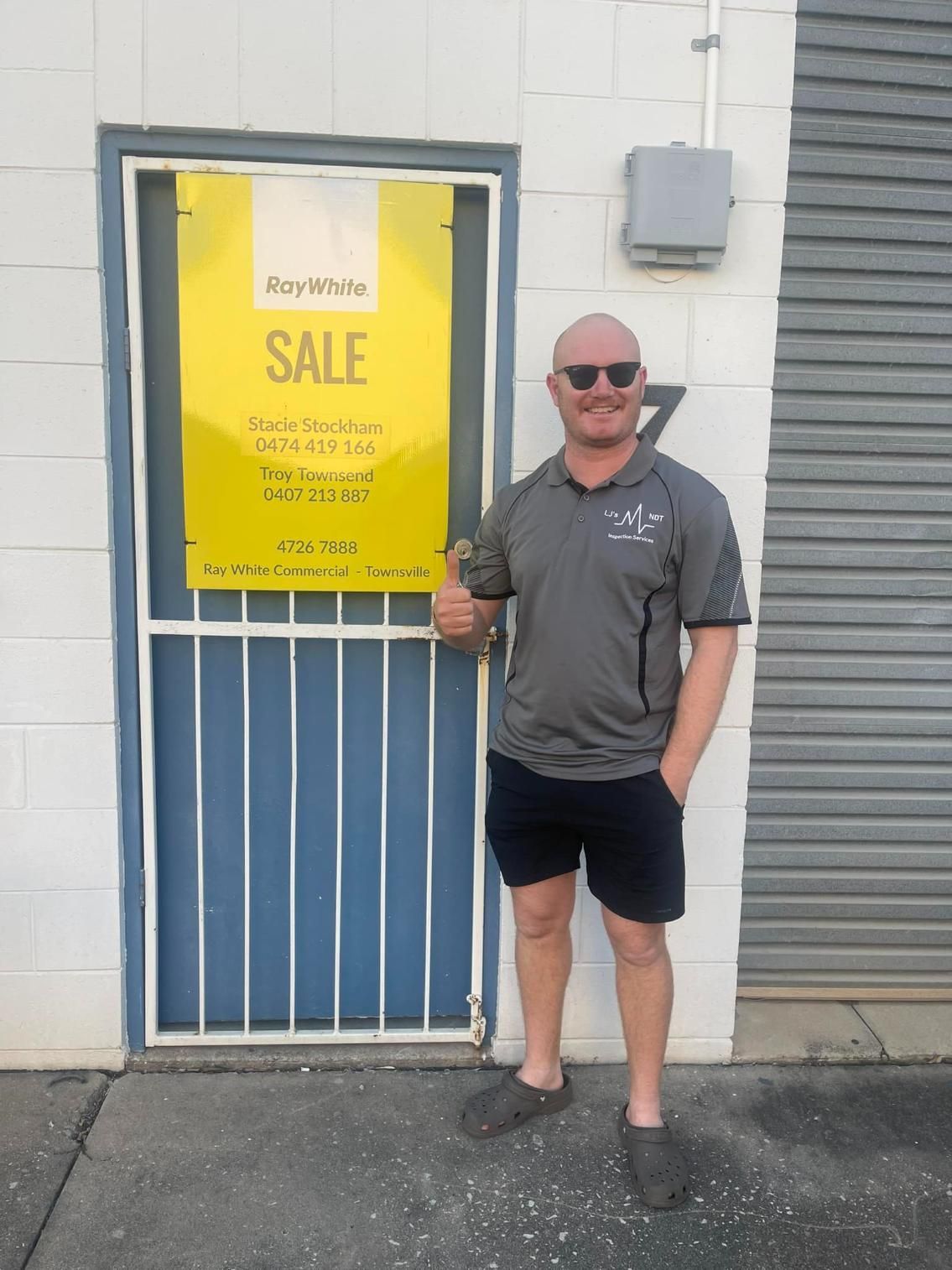 A Man Standing In Front Of A Door With A Yellow Sign That Says Sale — LJ's Technical Services In Burdell, QLD