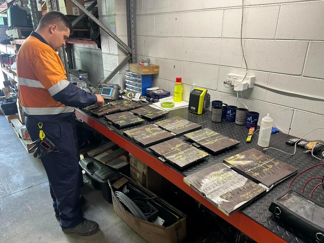 A Man Is Working On A Table In A Garage — LJ's Technical Services In Northern Territory, AU