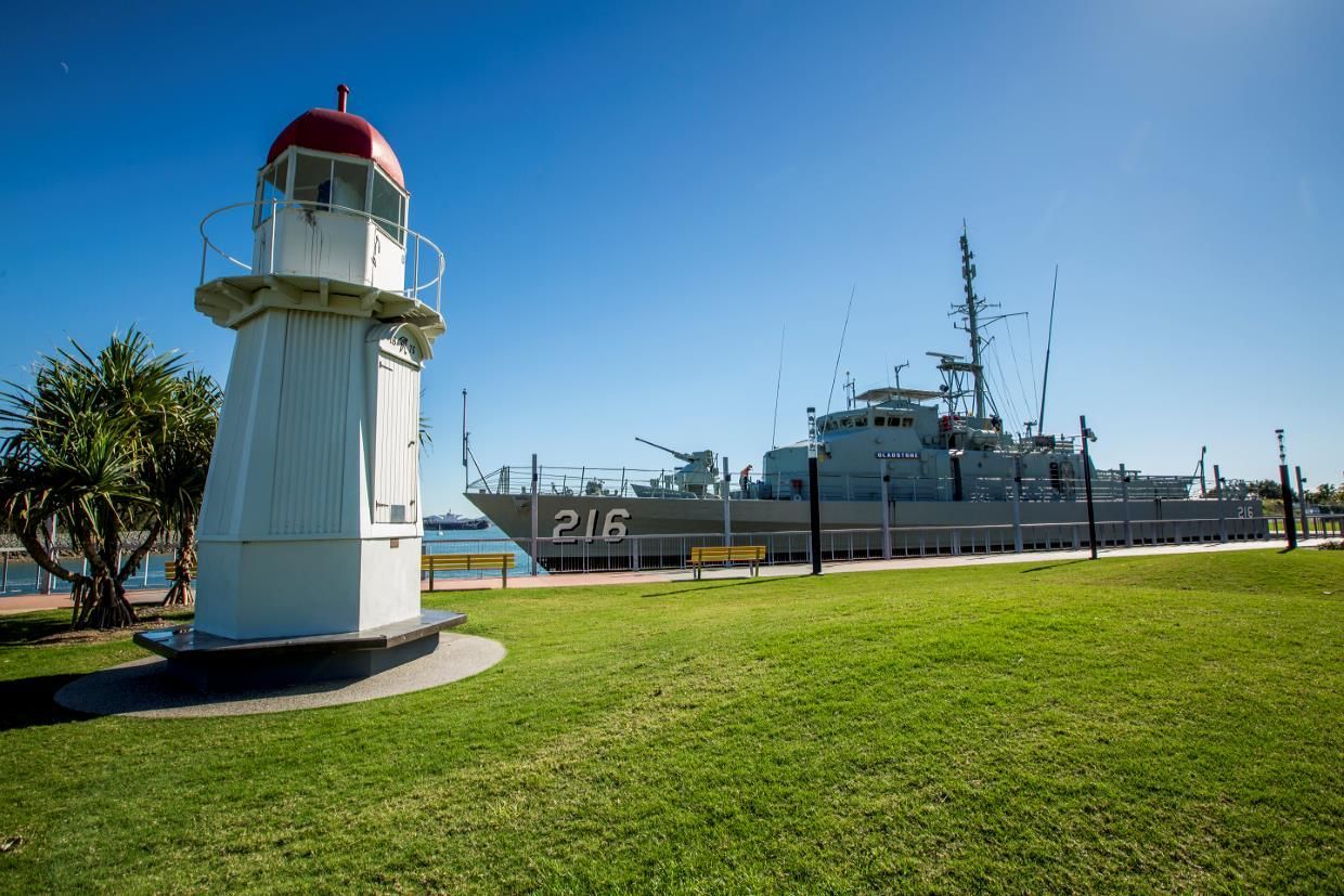 A Large Ship Is Docked Next To A Lighthouse In A Park — LJ's Technical Services In Gladstone, QLD