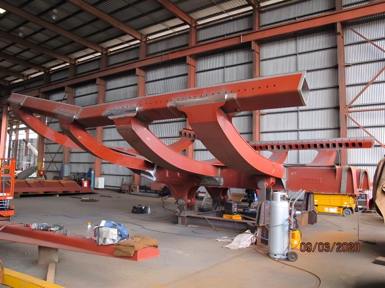 A Large Metal Structure Is Being Built In A Warehouse — LJ's Technical Services In Burdell, QLD