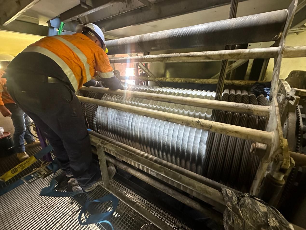 A Man Is Working On A Machine In A Factory — LJ's Technical Services In Mount Isa, QLD