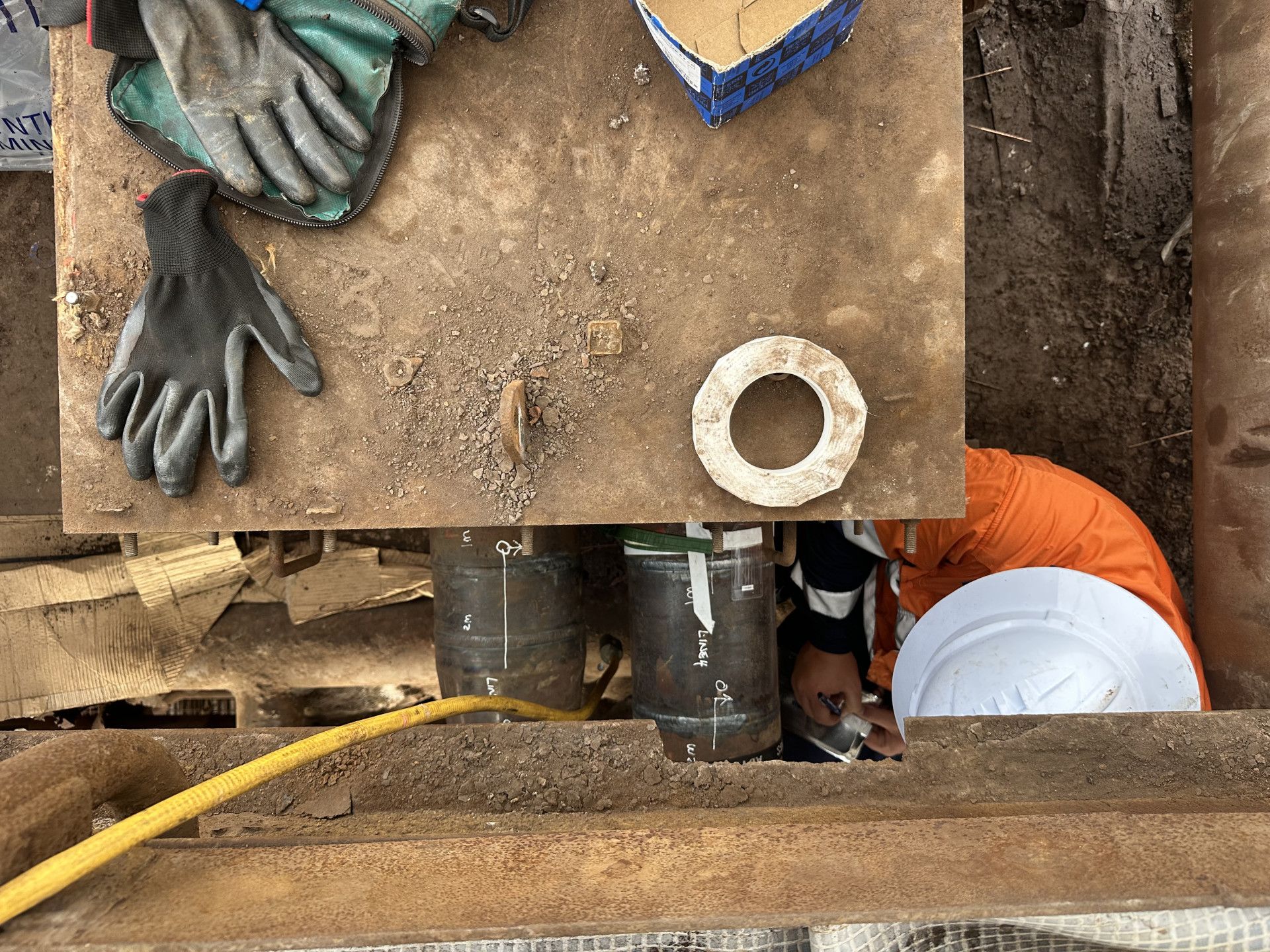 A Man working on pipes underground — LJ's Technical Services In Burdell, QLD