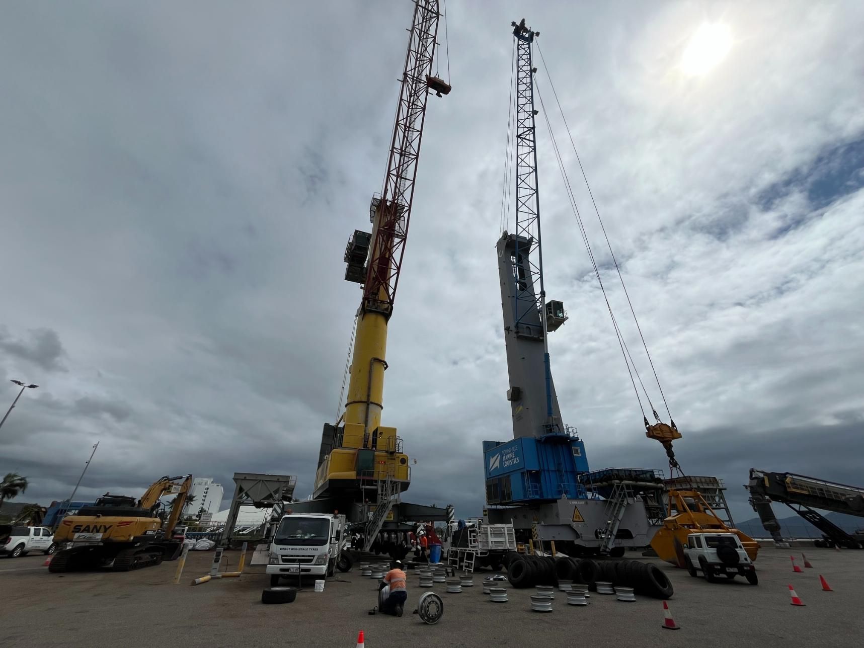 A Group Of Construction Cranes Are Parked In A Parking Lot — LJ's Technical Services In Burdell, QLD