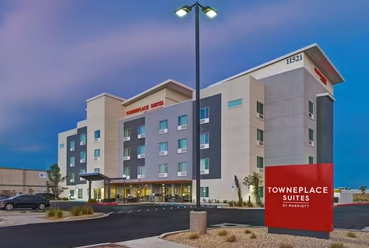 TownePlace Suites by Marriott hotel exterior at dusk. Red sign, gray and beige building.