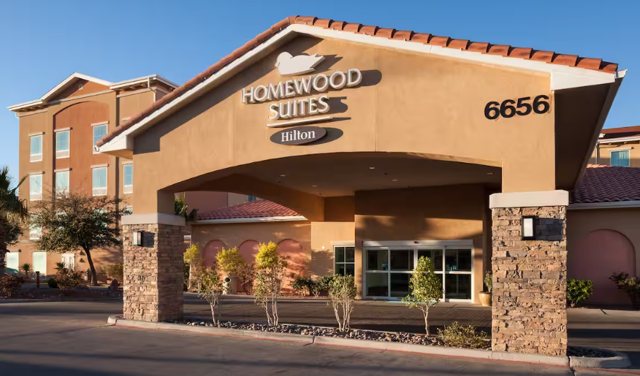 Homewood Suites hotel entrance with a brown stucco exterior and a covered walkway.