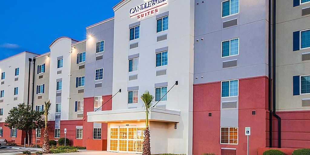 Hotel exterior with white and red walls, blue windows, and a sign.